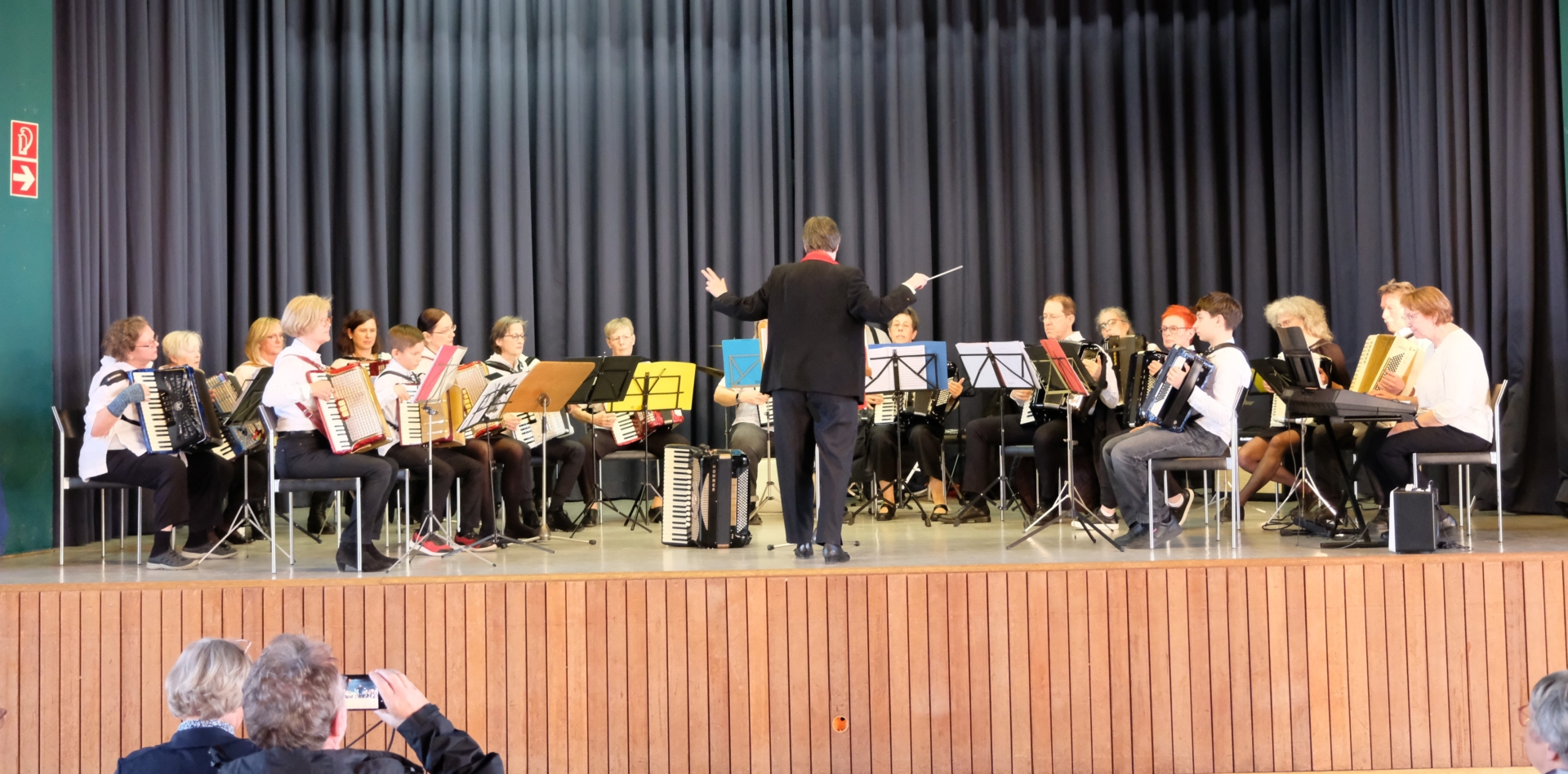 Ein großes generationenübergreifendes Workshop-Orchester spielt auf der Bühne.