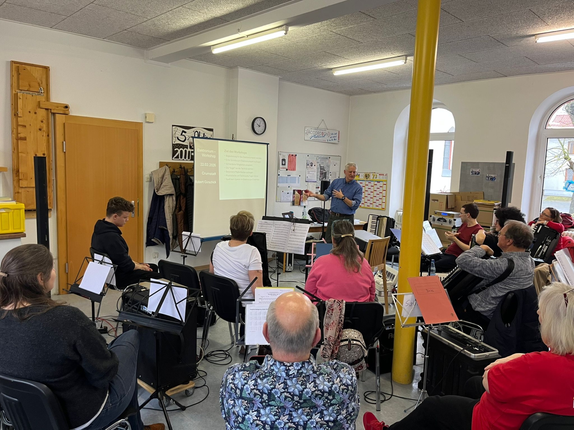Robert Girschick stellt die Ziele des Workshops vor. Die Teilnehmenden sitzen im Halbkreis und hören den Erläuterungen zu.