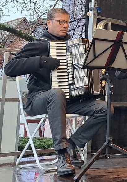 Das Bild zeigt Thorsten Kolar mit Akkordeon beim Auftritt des 1. Hofheimer Akkordeon-Vereins LYRA auf dem Weihnachtsmarkt 2024 in Hofheim