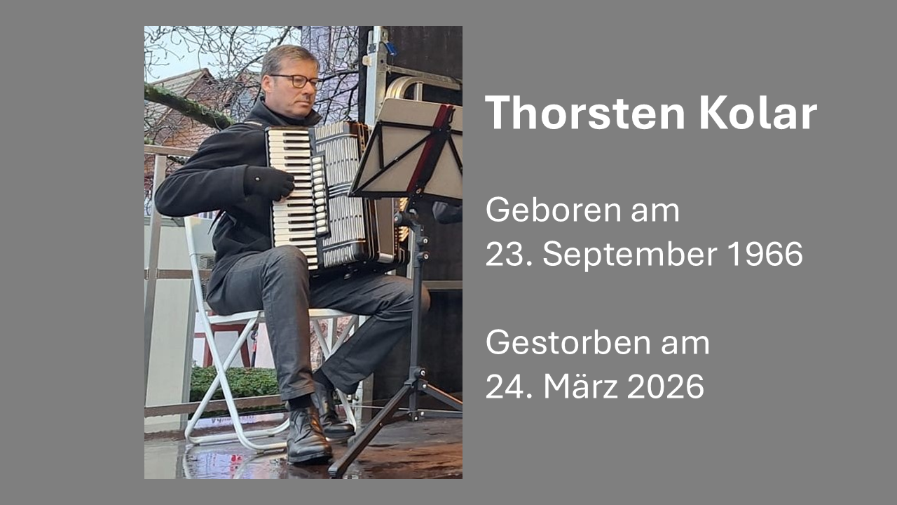 Thorsten Kolar sitzt mit seinem Akkordeon im Orchester auf der Open-air Bühne beim Auftritt auf dem Weihnachtsmarkt 2024 in Hofheim am Taunus
