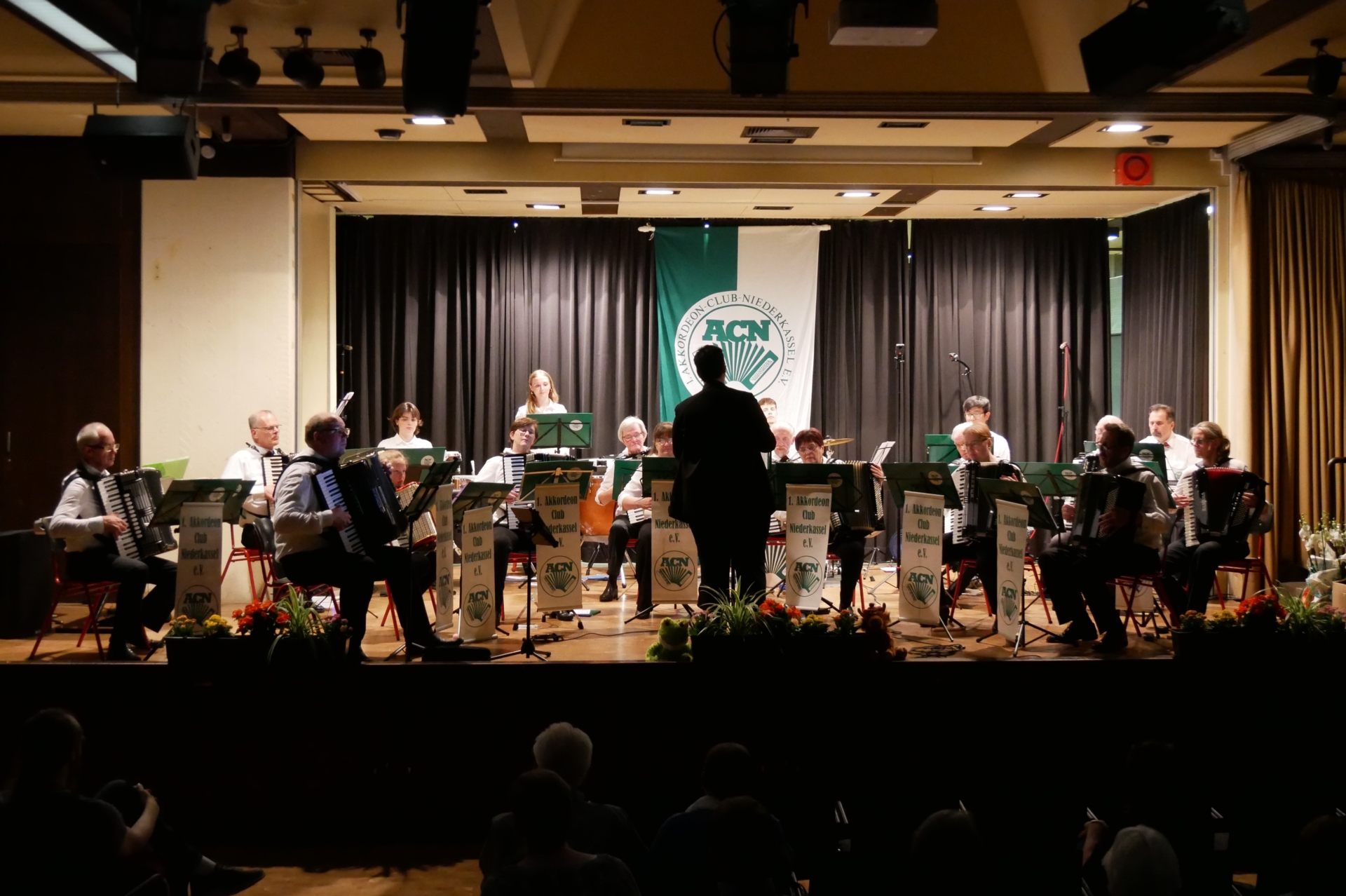 Das Orchester mit etwa 20 Aktiven auf der Bühne unter Leitung von Pia Clemens - leider waren Scheinwerfer ausgefallen.
