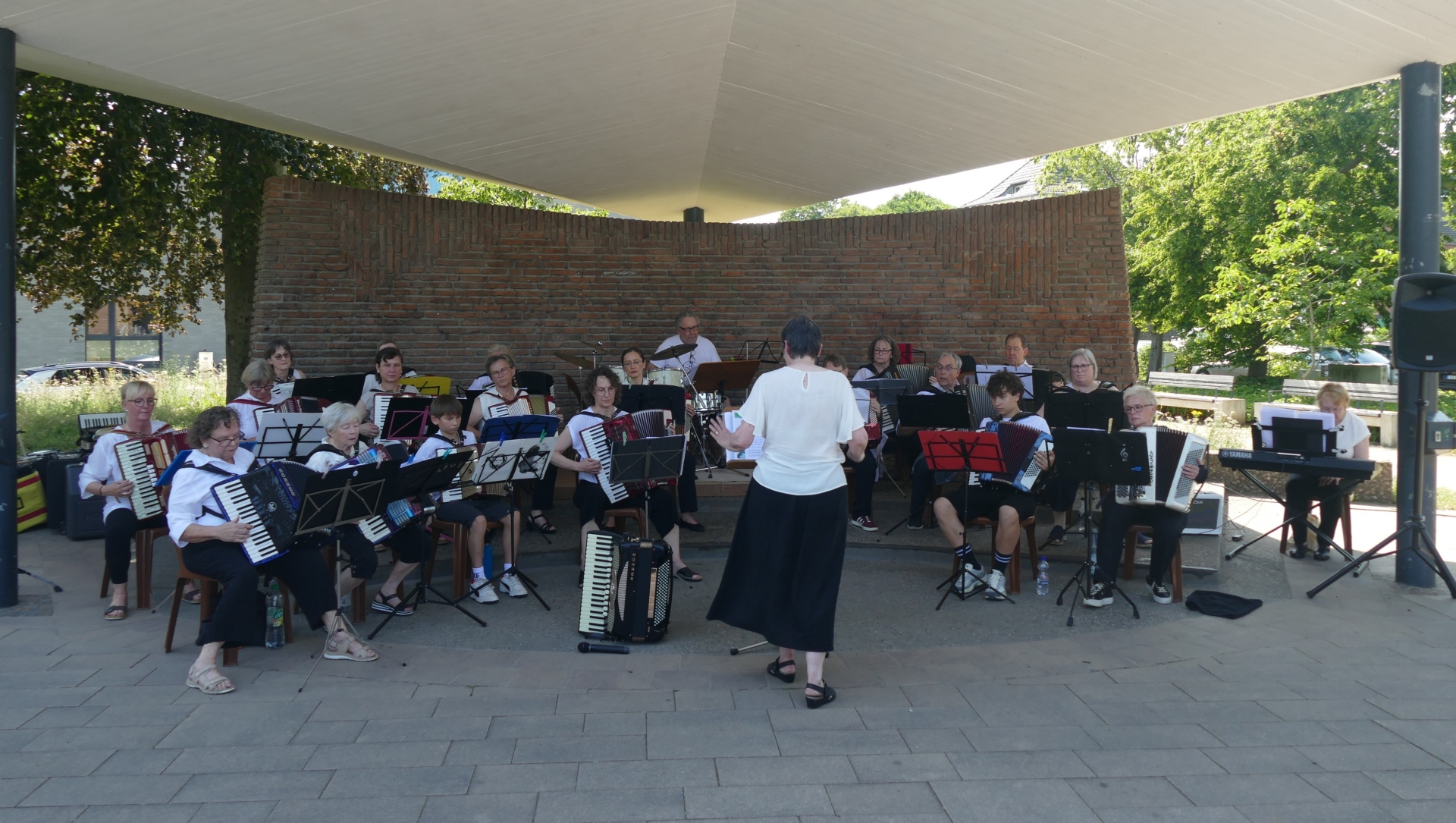 21 Musikerinnen und Musiker aller Generationen spielen im Musikpavillon unter Leitung von DIrigentin Anita Brandtstäter.
