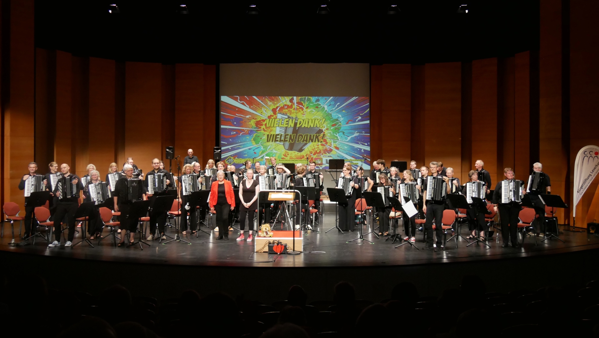 Applaus für über 50 stehende Musikerinnen und Musiker auf der Bühne des Forums Leverkusen - mit den beiden Dirigentinnen