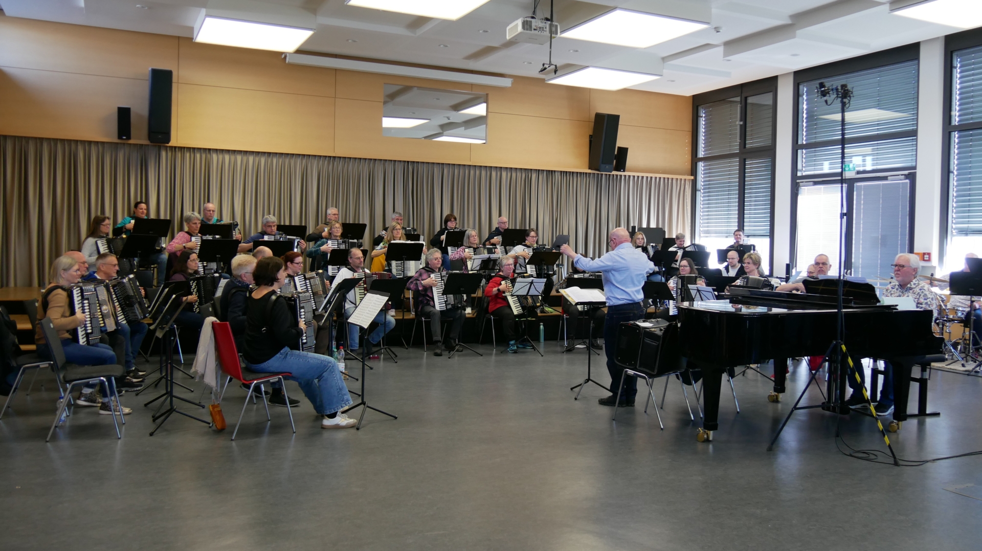Ein über 40 Mitglieder starkes Akkordeonorchester spielt unter Leitung von Wolfgang Russ. Am Flügel sitzt Hans-Günther Kölz.